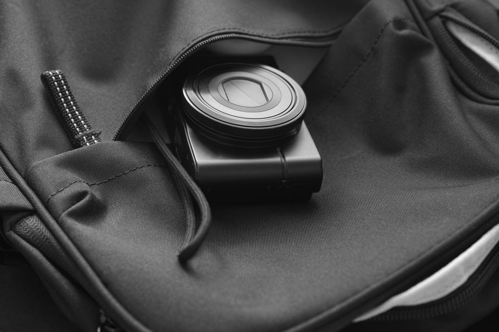 Compact camera inside a backpack. Black and White.